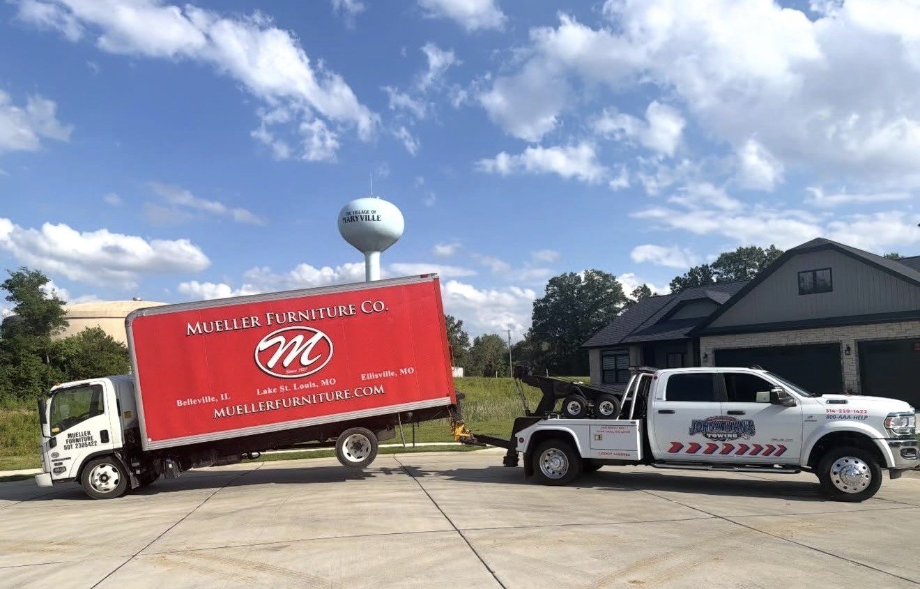 Commercial furniture delivery truck being towed