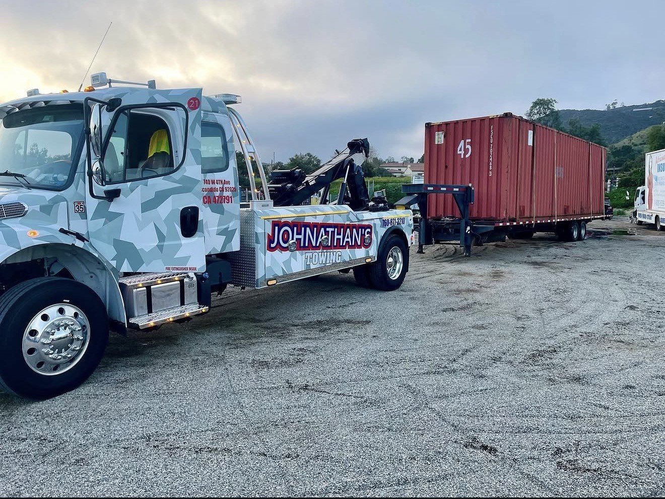 Shipping container being hauled by a Johnathan's Towing truck