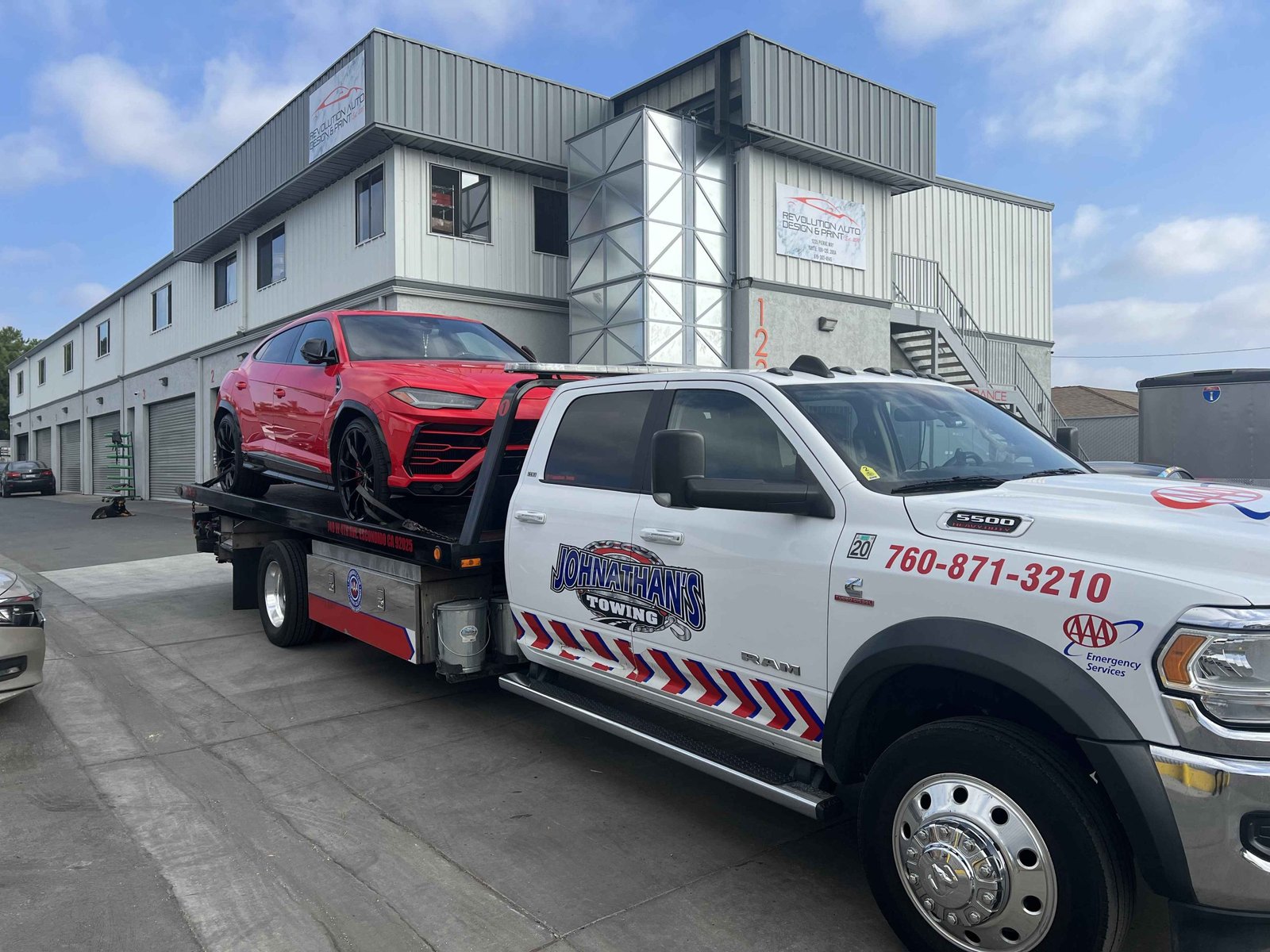 Johnathan's Towing flatbed truck transporting a luxury SUV